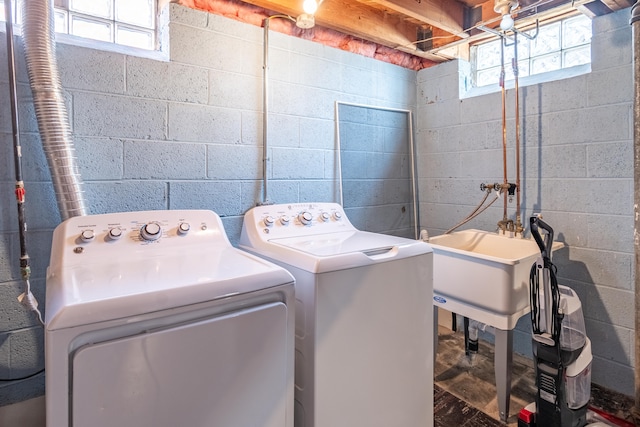 laundry area with laundry area, washing machine and dryer, and a healthy amount of sunlight