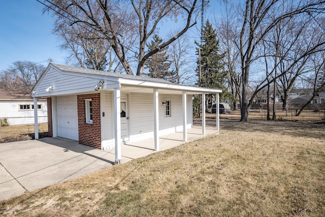 view of outdoor structure featuring concrete driveway and fence