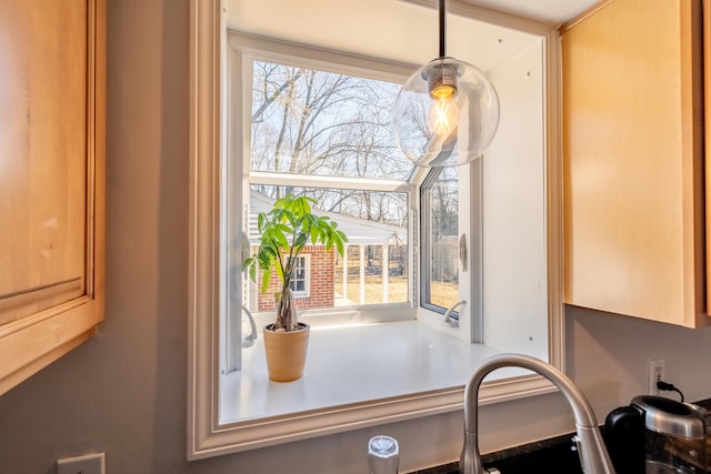 room details featuring a sink, decorative light fixtures, and light countertops