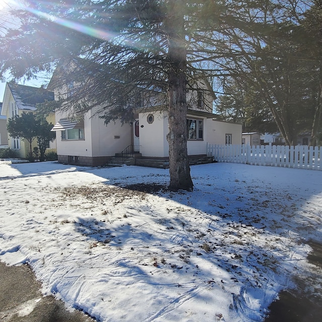 view of snowy exterior featuring fence