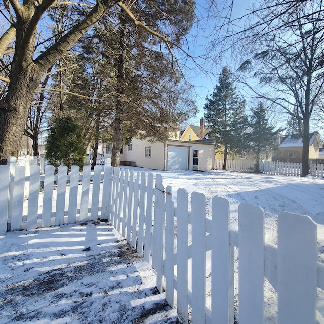 yard covered in snow with a fenced front yard