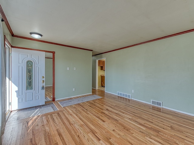 foyer featuring wood finished floors, visible vents, and baseboards