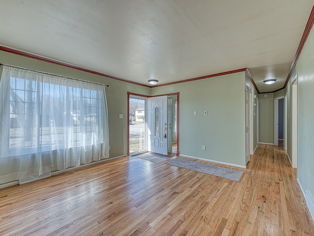 spare room with visible vents, light wood-type flooring, baseboards, and ornamental molding