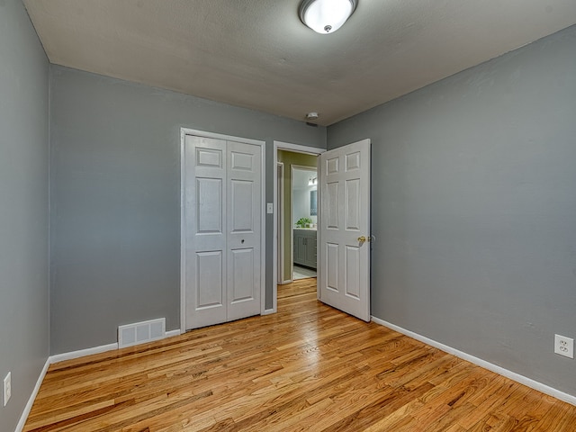 spare room with light wood-style flooring, baseboards, and visible vents