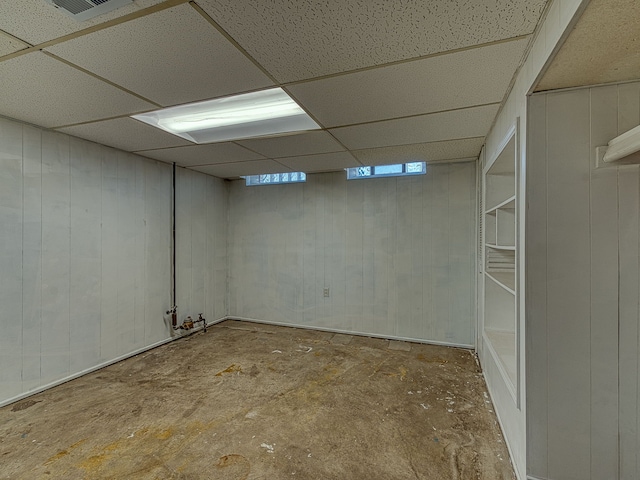 finished basement featuring a paneled ceiling