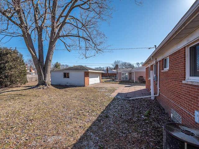 view of yard with a patio, cooling unit, fence, an outdoor structure, and a detached garage