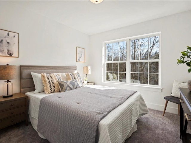 bedroom featuring baseboards and dark carpet