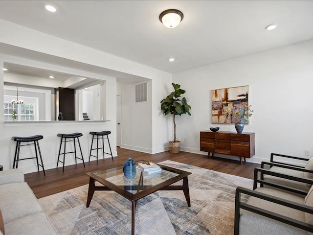 living area featuring visible vents, recessed lighting, baseboards, and wood finished floors