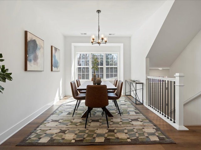 dining space with visible vents, baseboards, a notable chandelier, and wood finished floors