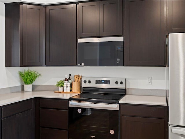 kitchen with dark brown cabinets, appliances with stainless steel finishes, and light countertops