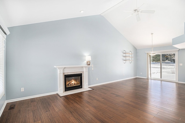 unfurnished living room with baseboards, high vaulted ceiling, wood finished floors, and a tile fireplace