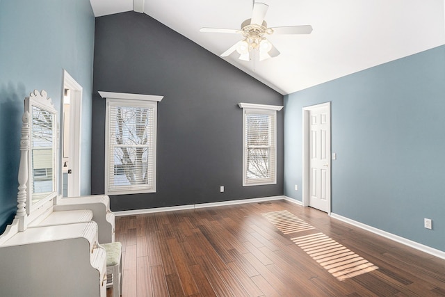 spare room featuring baseboards, high vaulted ceiling, wood finished floors, and a ceiling fan