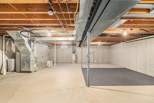 unfinished basement featuring heating unit, gas water heater, and brick wall