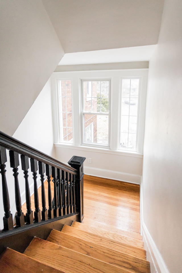 staircase with baseboards and wood finished floors