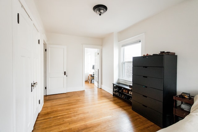 bedroom featuring baseboards and light wood finished floors