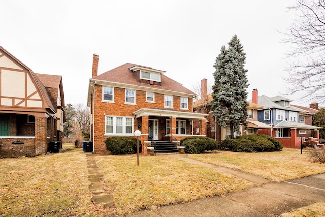 traditional style home featuring a front yard, central air condition unit, brick siding, and a chimney