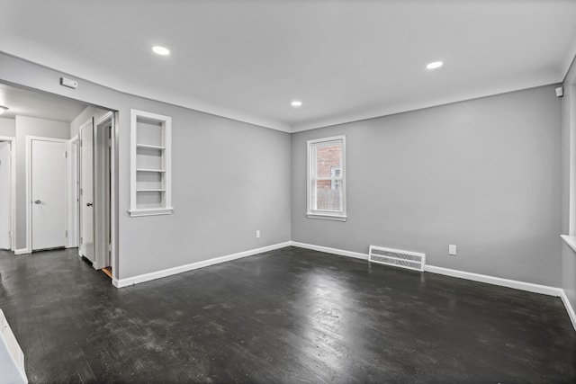 spare room featuring visible vents, recessed lighting, built in shelves, and baseboards