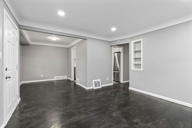 empty room with recessed lighting, visible vents, baseboards, and built in shelves