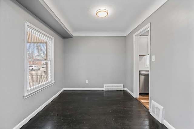 empty room featuring visible vents, baseboards, and wood finished floors