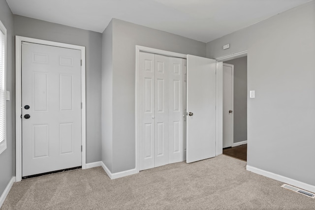 unfurnished bedroom featuring carpet, visible vents, and baseboards