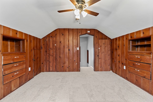 additional living space with lofted ceiling, carpet flooring, and wood walls