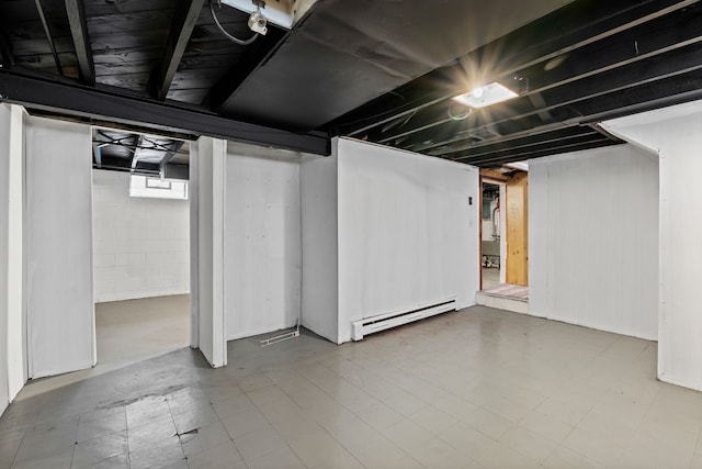 basement featuring a baseboard heating unit and tile patterned floors