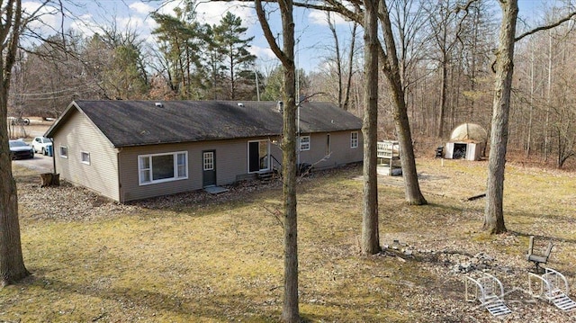 back of house featuring roof with shingles