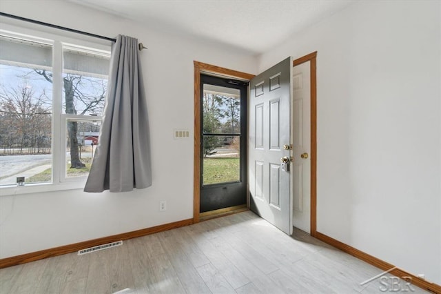 foyer featuring visible vents, light wood-style flooring, and baseboards