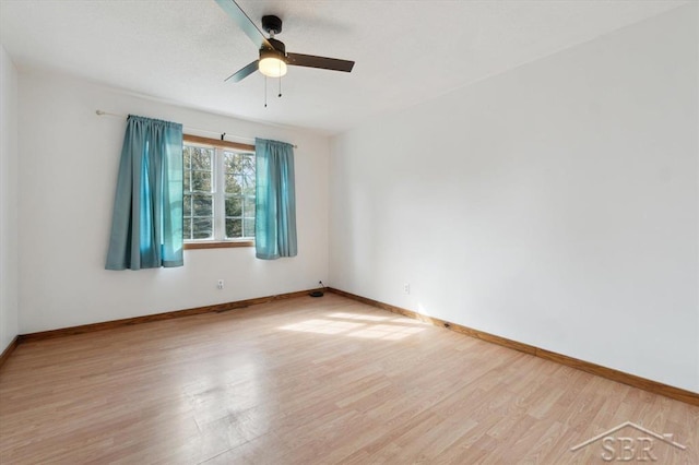 empty room featuring wood finished floors, baseboards, and ceiling fan