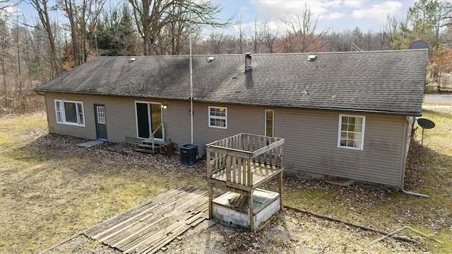 rear view of property featuring central air condition unit, roof with shingles, and entry steps