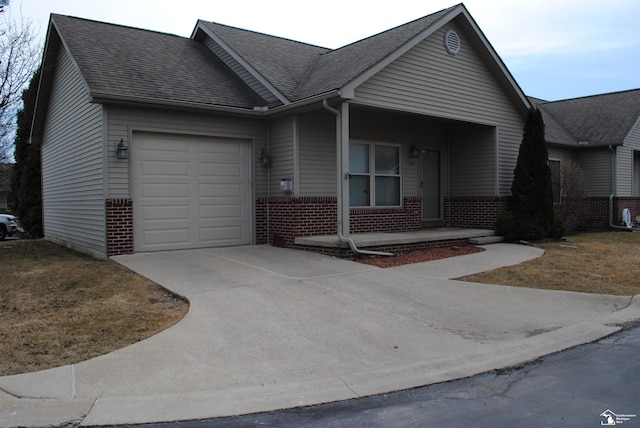 view of front of home with concrete driveway, an attached garage, brick siding, and roof with shingles