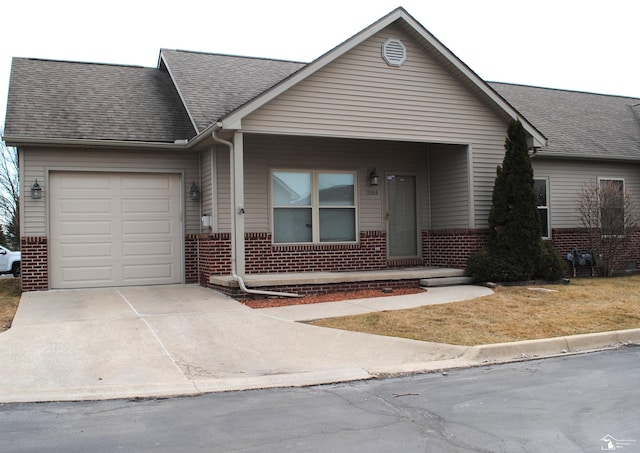 view of front of house with a garage, brick siding, roof with shingles, and concrete driveway