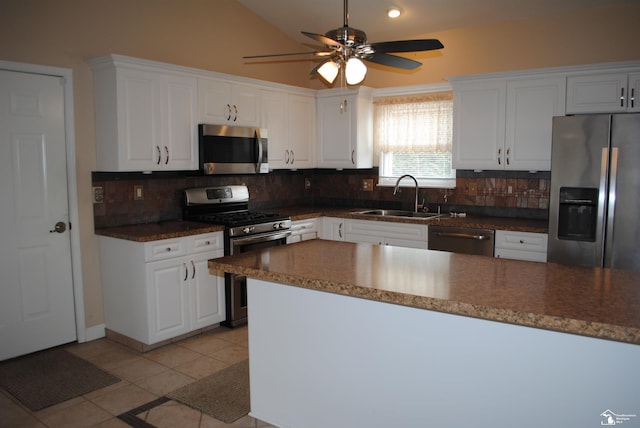 kitchen featuring a sink, stainless steel appliances, light tile patterned floors, decorative backsplash, and lofted ceiling