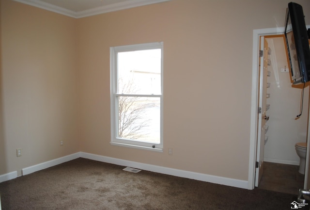 unfurnished room featuring visible vents, carpet flooring, crown molding, and baseboards