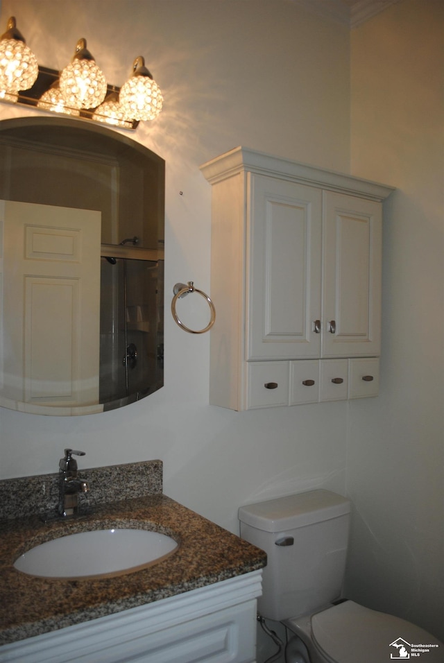 bathroom with an enclosed shower, toilet, and vanity