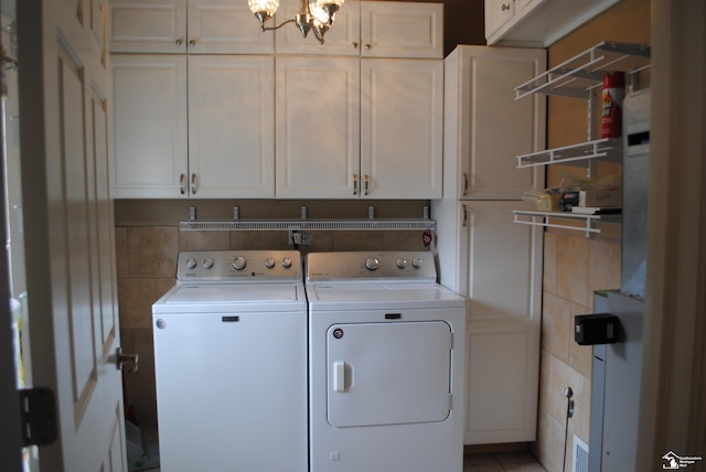 laundry room with washer and dryer, cabinet space, tile walls, and an inviting chandelier