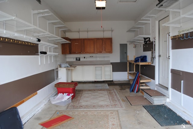 kitchen featuring unfinished concrete floors, light countertops, electric panel, brown cabinets, and open shelves