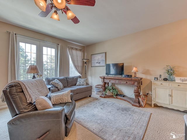 living area with baseboards and ceiling fan