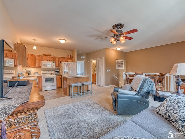 living area featuring baseboards, light colored carpet, and ceiling fan