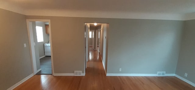 unfurnished room with plenty of natural light, baseboards, and wood finished floors