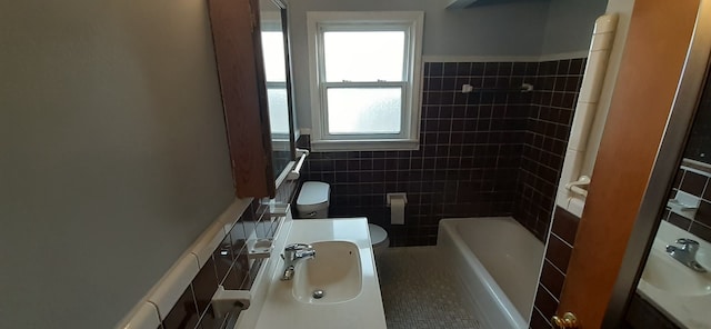 bathroom featuring shower / bathing tub combination, a sink, tile walls, toilet, and tile patterned floors