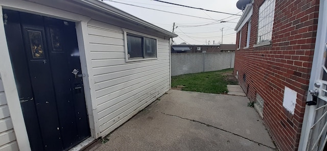 view of side of property with brick siding and fence