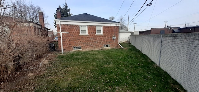 view of home's exterior with brick siding, a chimney, a yard, and fence