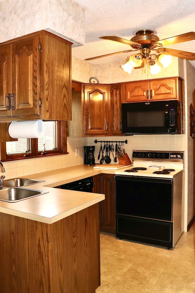 kitchen featuring a sink, electric range oven, light countertops, black microwave, and backsplash