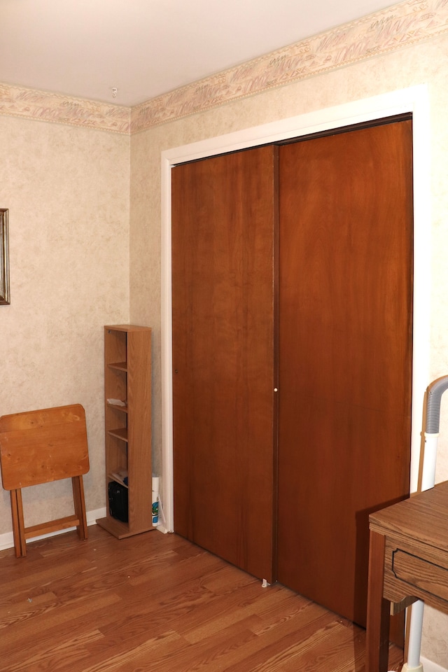 interior space featuring a closet, baseboards, and wood finished floors