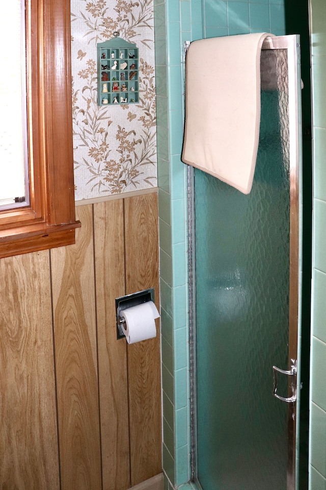 bathroom featuring a stall shower and wallpapered walls