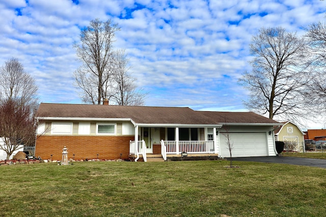 ranch-style house featuring a front lawn, covered porch, a chimney, a garage, and driveway