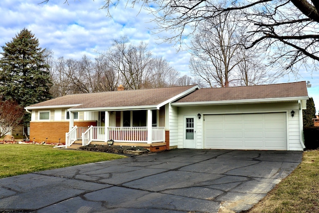 ranch-style home featuring aphalt driveway, a front yard, covered porch, a chimney, and a garage