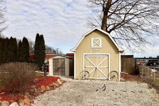 view of barn featuring fence