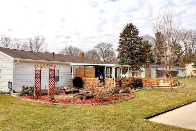 rear view of house with a chimney, a pergola, and a yard